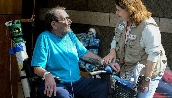 Red Cross Health Volunteer Helping Older Man