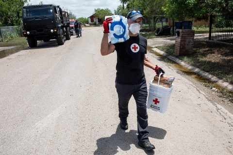 A Red Cross volunteer carries disaster relief supplies
