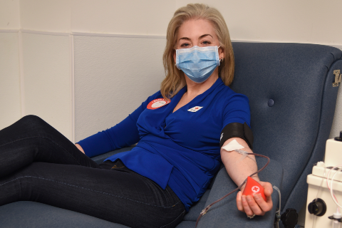 A woman donates blood at a Red Cross blood drive